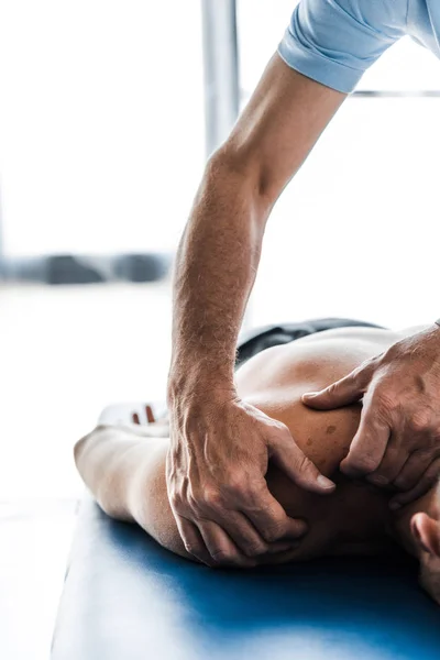 Abgeschnittene Ansicht eines Chiropraktikers, der muskulöse Patienten massiert — Stockfoto