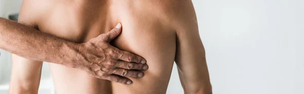 Plan panoramique du médecin touchant le dos d'un patient torse nu — Photo de stock