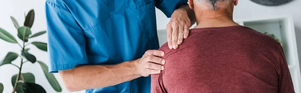 Panoramic shot of doctor touching shoulder of man — Stock Photo