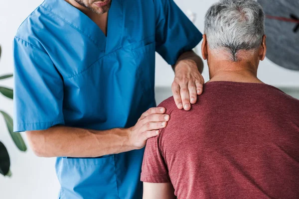 Rückenansicht des Patienten, der in der Nähe des Arztes in der Klinik sitzt — Stockfoto