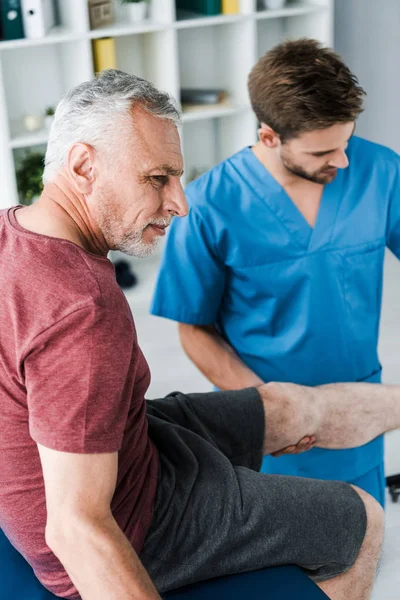 Foyer sélectif du patient barbu avec douleur près du médecin — Photo de stock