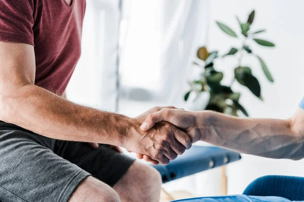 Cropped view of doctor shaking hands with man — Stock Photo
