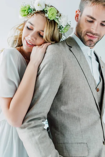 Attraktive Braut und schöner Bräutigam lächeln und schauen isoliert auf grau — Stockfoto