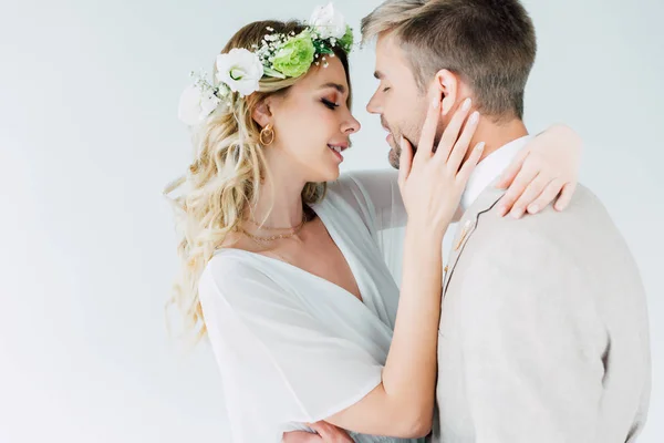 Attractive bride and handsome bridegroom hugging and kissing with closed eyes — Stock Photo