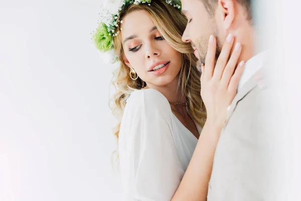 Attractive bride and handsome bridegroom hugging and looking away — Stock Photo