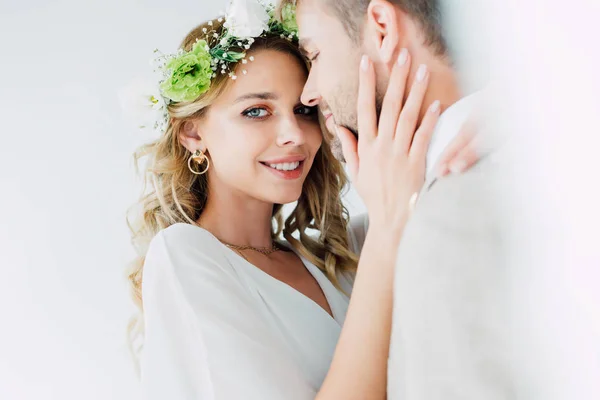 Atractiva novia y guapo novio abrazando y mirando a la cámara - foto de stock