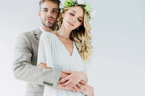 Attraktive Braut und schöner Bräutigam umarmen und wegschauen — Stockfoto