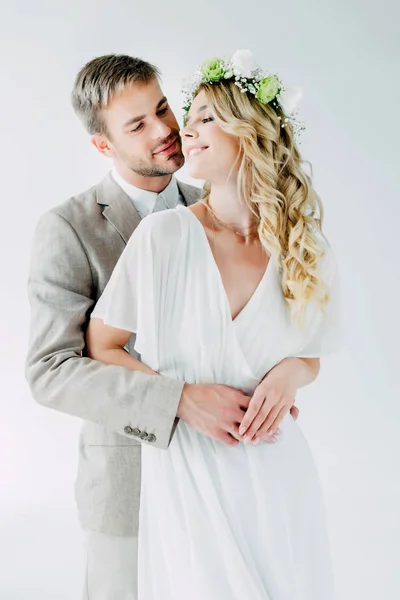 Attraktive Braut und schöner Bräutigam umarmen sich und schauen einander an — Stockfoto