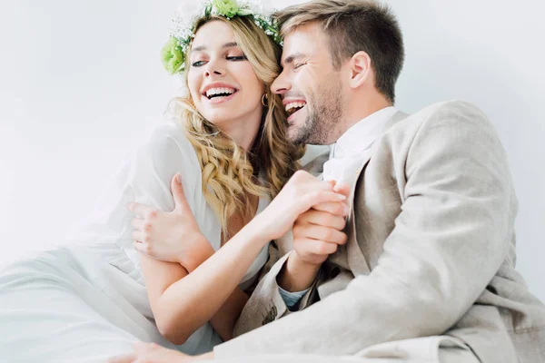 Attractive bride and handsome bridegroom holding hands and looking away — Stock Photo