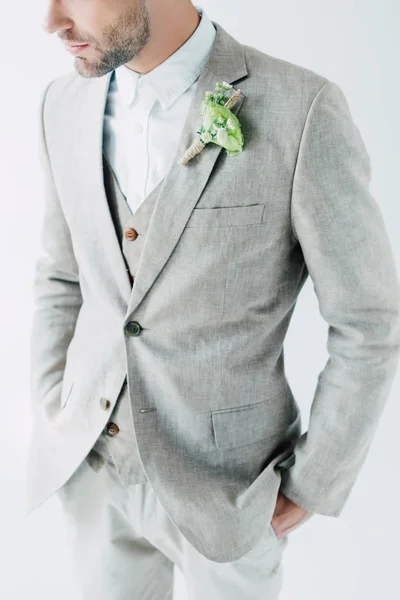 Cropped view of bridegroom in suit with hands in pockets isolated on grey — Stock Photo