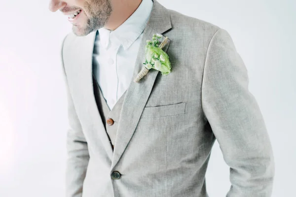 Cropped view of smiling bridegroom in suit with boutonniere isolated on grey — Stock Photo