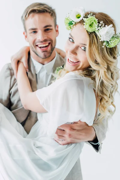 Attractive bride and handsome bridegroom hugging and looking at camera — Stock Photo