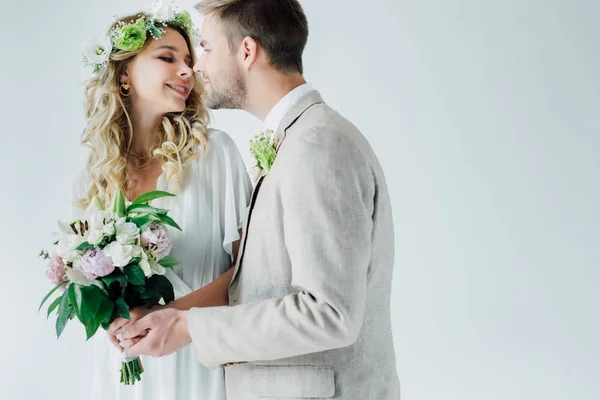 Attraktive Braut und schöner Bräutigam küssen und schauen einander an — Stockfoto