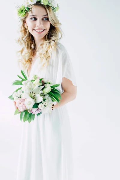 Attractive bride in wedding dress and wreath holding bouquet isolated on white — Stock Photo