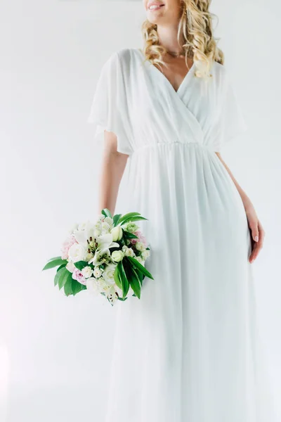 Vue recadrée de la mariée en robe de mariée tenant bouquet isolé sur blanc — Photo de stock