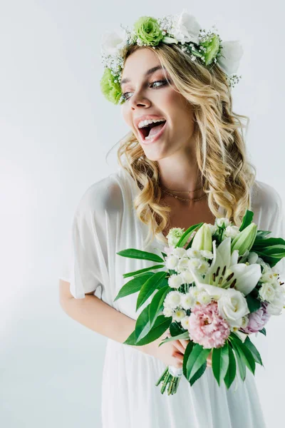 Noiva atraente em vestido de noiva e coroa segurando buquê isolado no branco — Fotografia de Stock