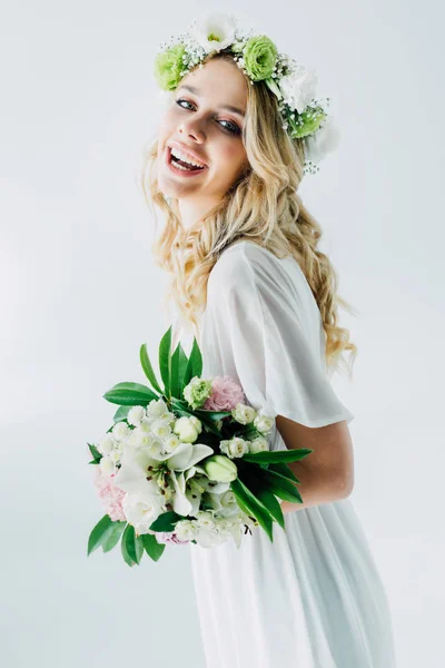 Jolie mariée en robe de mariée et couronne tenant bouquet isolé sur blanc — Photo de stock