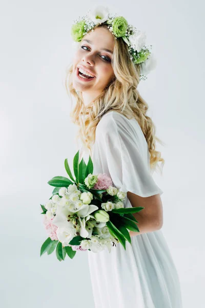 Noiva atraente em vestido de noiva e coroa segurando buquê isolado no branco — Fotografia de Stock