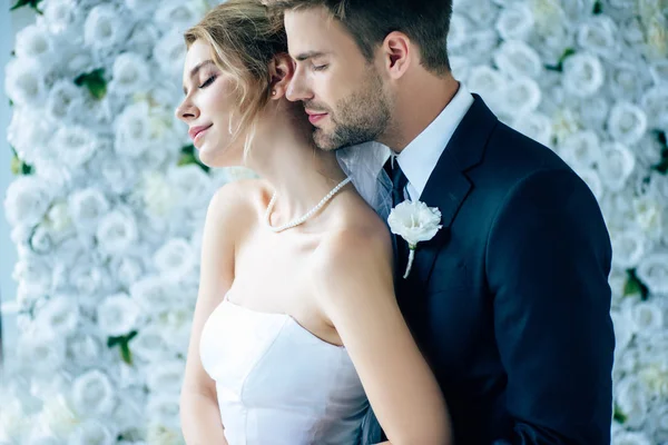 Attrayant mariée et beau marié câlin avec les yeux fermés — Photo de stock