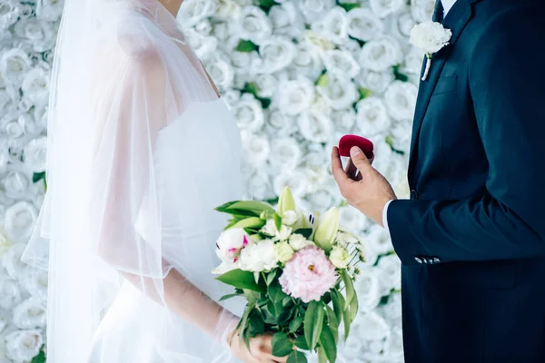 Vue de côté du marié faisant la proposition de mariée en robe de mariée — Photo de stock