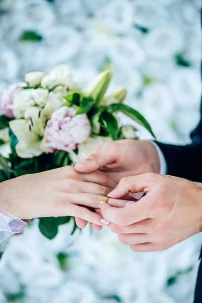 Vista recortada del novio poniendo anillo de bodas en el dedo - foto de stock