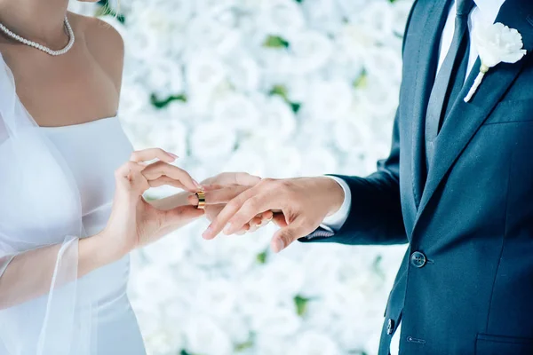 Vista cortada da noiva colocando anel de casamento no dedo — Fotografia de Stock