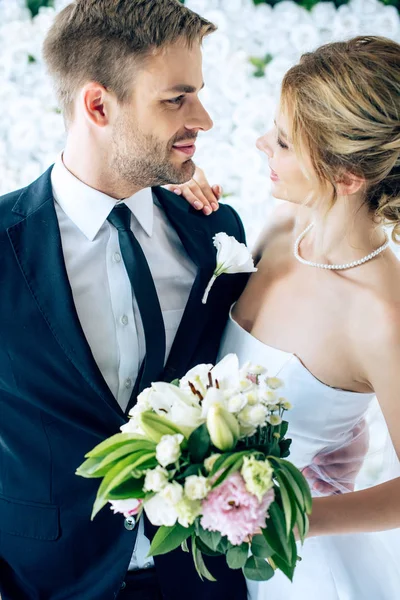 Attraente sposa e bello sposo guardando l'un l'altro — Foto stock