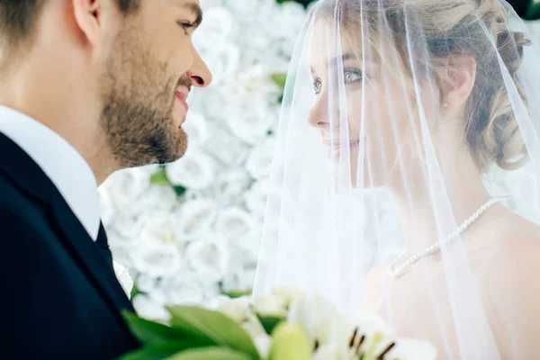 Attraktive Braut und schöner Bräutigam schauen einander an — Stockfoto