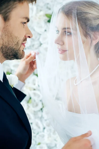 Attraktive Braut und schöner Bräutigam schauen einander an — Stockfoto