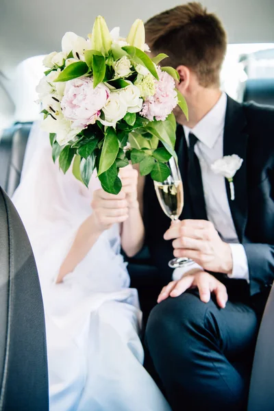 Selective focus of bridegroom in suit and bride holding bouquet — Stock Photo