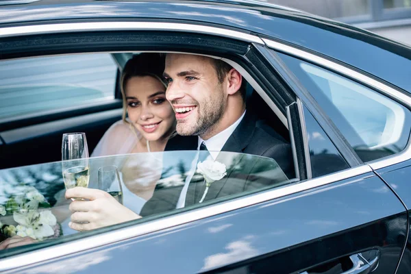 Mariée attrayante et beau marié tenant verre de champagne — Photo de stock