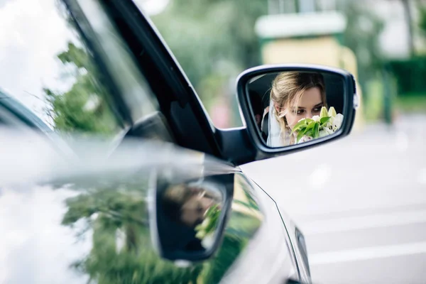 Reflet d'attrayant et blonde mariée bouquet odorant dans la voiture — Photo de stock