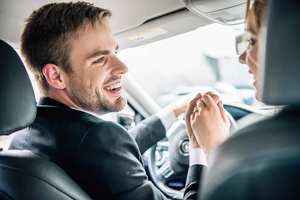 Cropped view of bridegroom smiling and holding hand of bride — Stock Photo