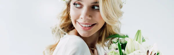 Colpo panoramico di attraente e bionda sposa tenendo bouquet isolato su bianco — Foto stock