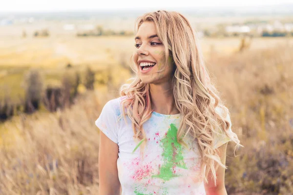 Atractiva mujer en camiseta sonriendo y mirando hacia afuera - foto de stock