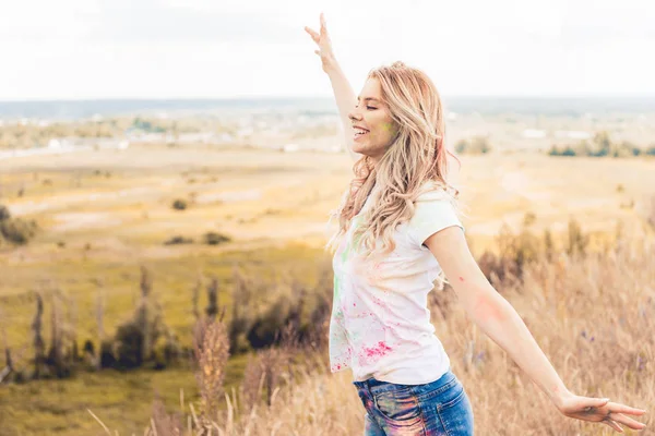 Jolie femme en t-shirt avec les mains tendues souriant et détournant les yeux — Photo de stock