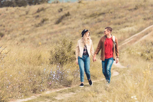 Atractiva mujer y hombre guapo sonriendo y tomados de la mano - foto de stock