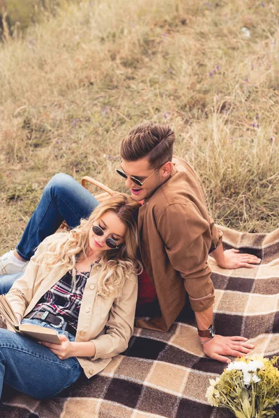 Mulher atraente e homem bonito em óculos de sol livro de leitura — Fotografia de Stock