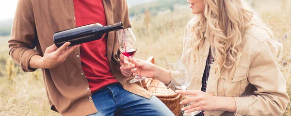 Plan panoramique de l'homme versant du vin au verre à l'extérieur — Photo de stock