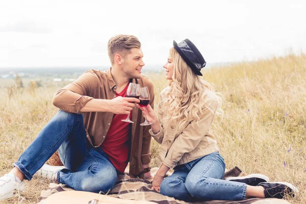 Handsome man and attractive woman clinking with wine glasses — Stock Photo