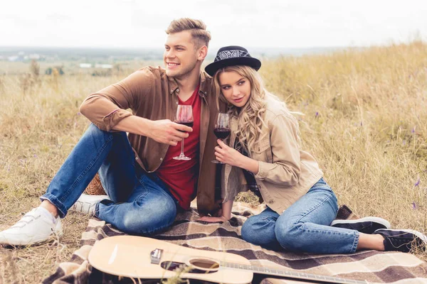 Handsome man and attractive woman smiling and holding wine glasses — Stock Photo