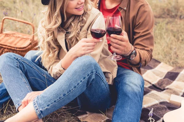 Vista recortada del hombre y la mujer tintineo con copas de vino - foto de stock