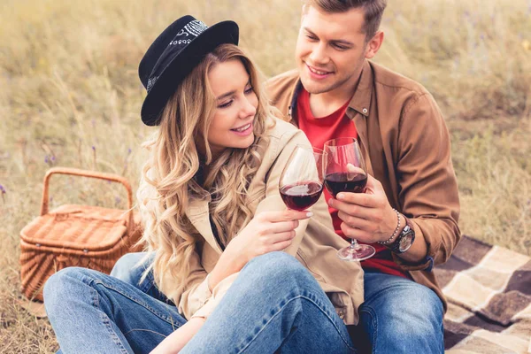 Hombre guapo y atractiva mujer tintineo con copas de vino - foto de stock