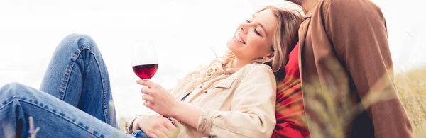 Panoramic shot of man and attractive woman holding wine glass — Stock Photo