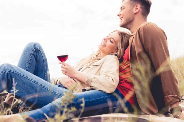 Bel homme regardant loin et femme attrayante tenant verre de vin — Photo de stock