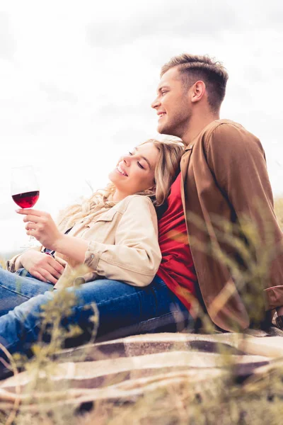 Homem bonito olhando para longe e mulher atraente segurando copo de vinho — Fotografia de Stock