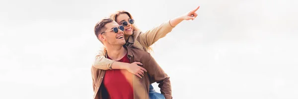 Tiro panorámico de hombre guapo a cuestas su novia atractiva y rubia - foto de stock