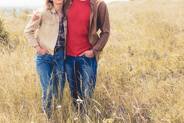 Обрізаний вид жінки і чоловіка в джинсах, що обіймаються зовні — стокове фото
