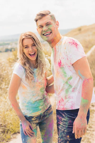 Atractiva mujer y hombre guapo sonriendo y abrazándose fuera - foto de stock