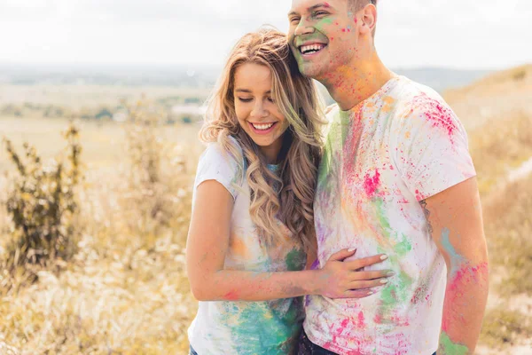 Atractiva mujer y hombre guapo sonriendo y abrazándose fuera - foto de stock